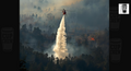 A helicopter is dropping a large amount of water on a forest fire, creating a plume of smoke and steam as it extinguishes the flames.