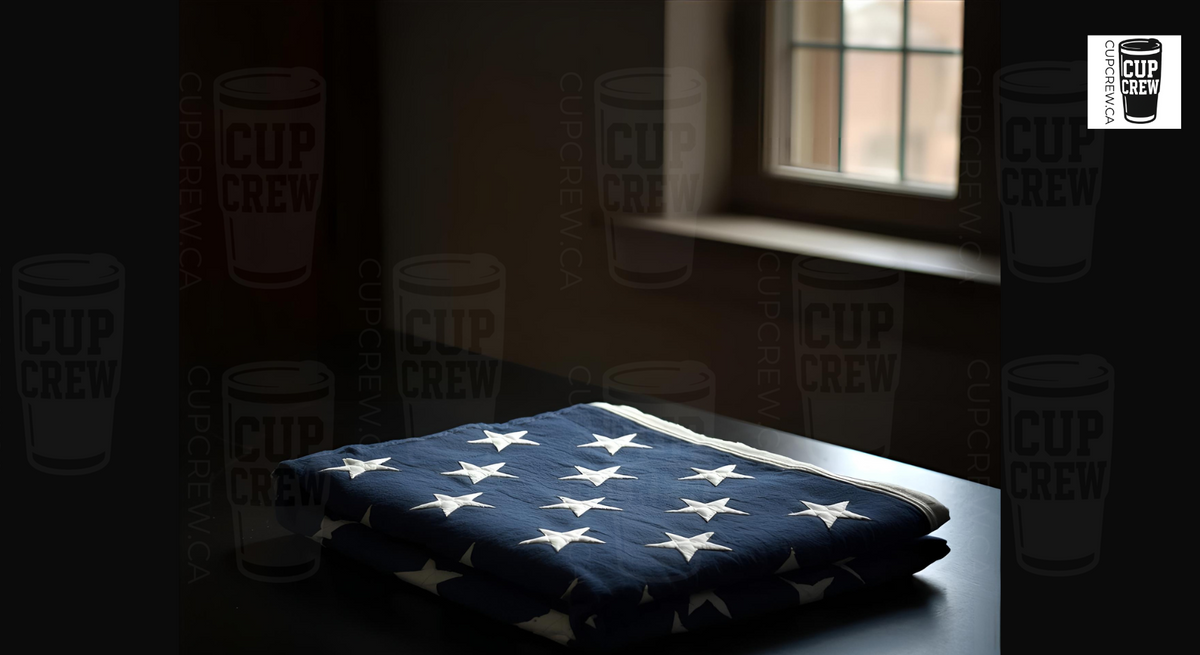 a folded American flag with white stars on a dark surface, with a window and cups with the word "CUP CREW" visible in the background.