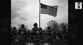 A group of firefighters standing in front of an American flag, with a cup of coffee on the right side of the image.