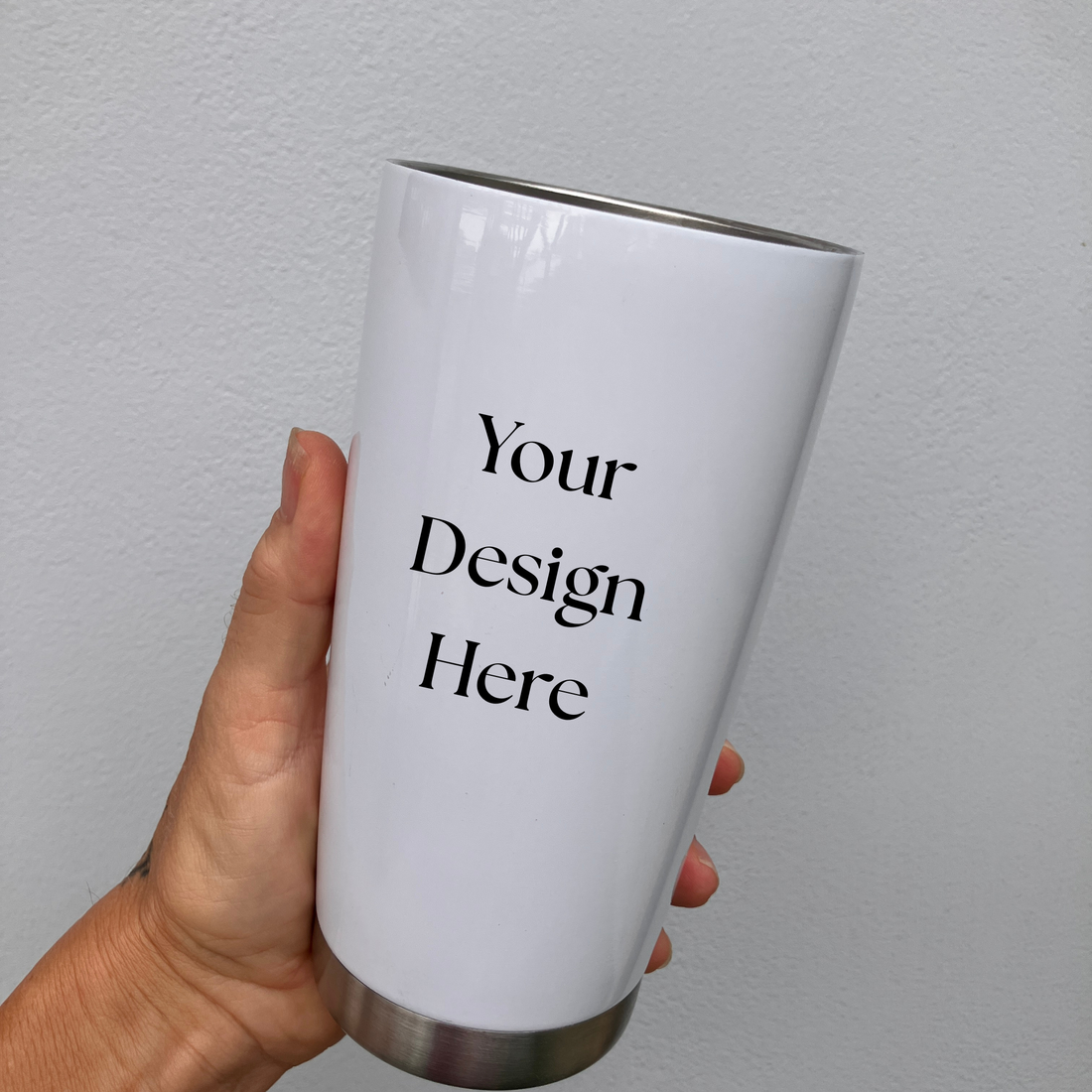 a tall, black and white Eiffel Tower printed on a stainless steel tumbler with a black handle, placed on a wooden surface.
